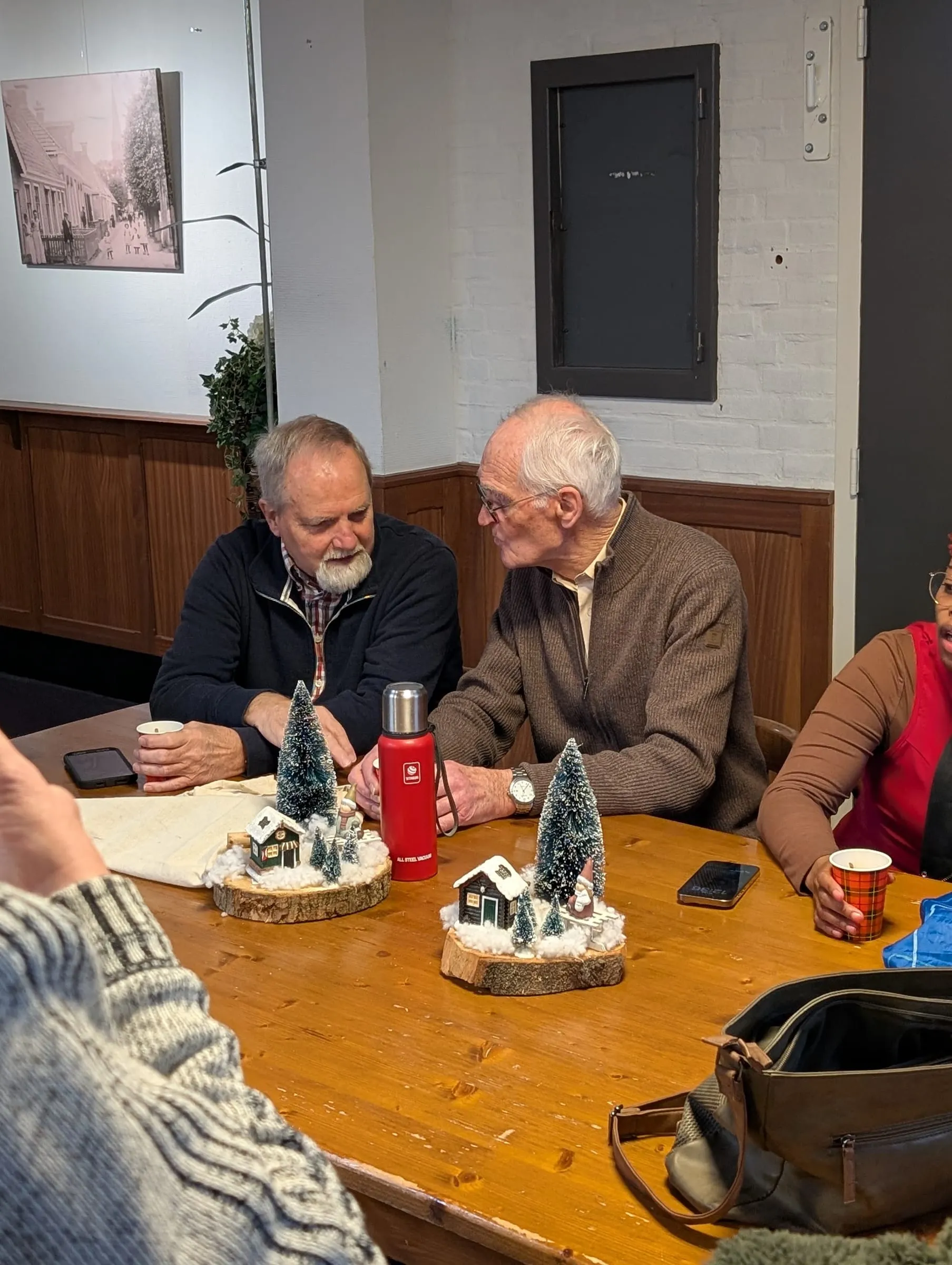 Twee senioren in gesprek aan tafel tijdens de seniorenochtend